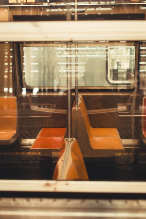 Free Intimate view of empty subway seats through glass, evoking urban solitude. Stock Photo