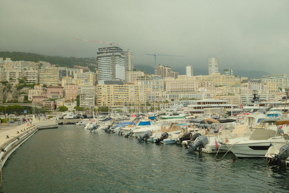Monaco harbor in daytime with yachts and skyline, showcasing urban architecture and Mediterranean vibe.