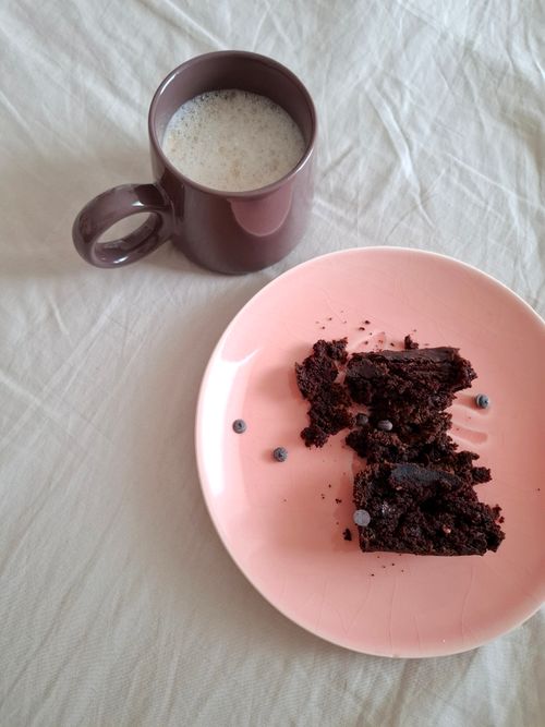 Free A cozy breakfast scene with chocolate cake on a pink plate and coffee in a mug. Stock Photo