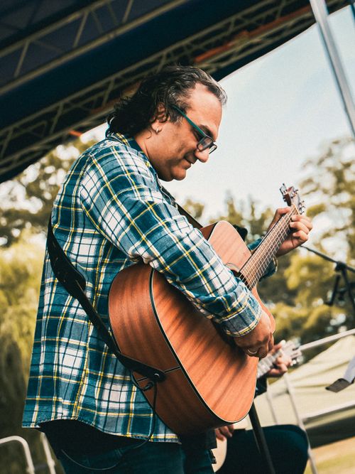 Free A musician passionately playing guitar at an outdoor music festival. Stock Photo