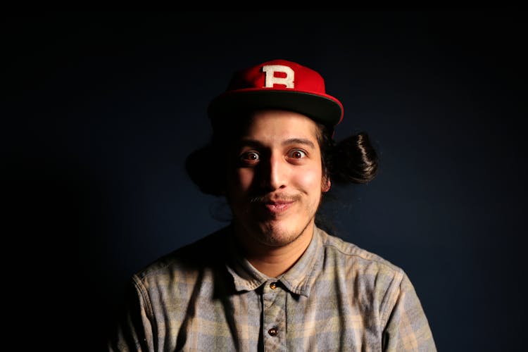 Man Wearing Red Fitted Cap And Brown And Gray Plaid Collared Hsirt