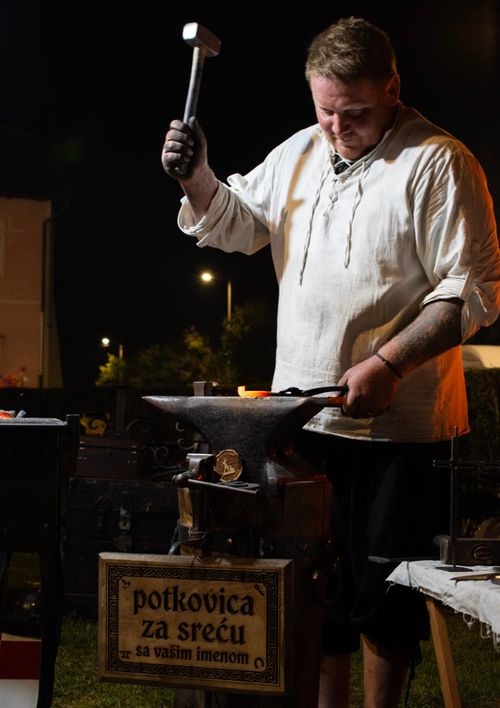Free A traditional blacksmith crafting a lucky horseshoe outside at night in Voloder, Croatia. Stock Photo