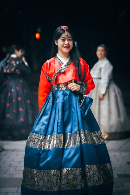 Free Woman wearing a traditional hanbok dress in Seoul, Korea during a cultural event at night. Stock Photo