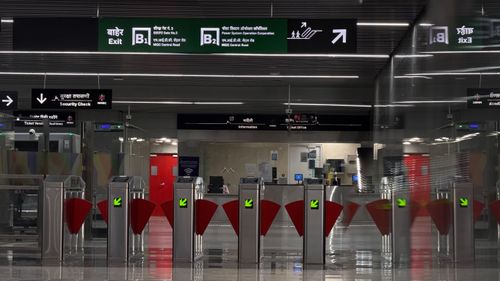 Free Entrance to a modern metro station with automated gates and bilingual signs. Stock Photo