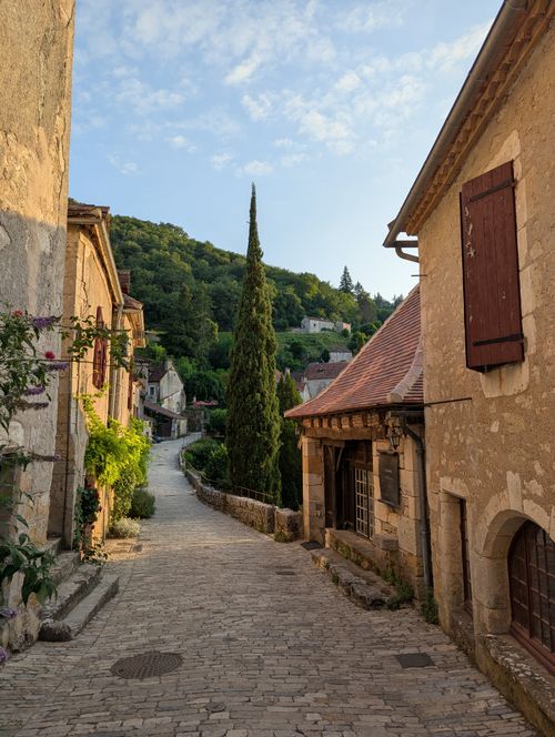 Free Discover the timeless charm of a cobblestone street in Saint-Cirq-Lapopie at sunset. Stock Photo