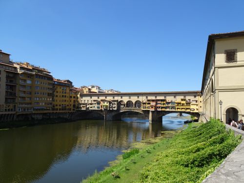Free Explore the historic Ponte Vecchio bridge spanning the Arno River in Florence, Italy on a sunny day. Stock Photo