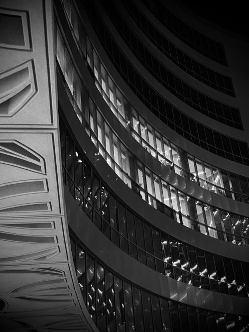 Free Black and white photo of modern architecture showcasing curved glass facade at night. Stock Photo