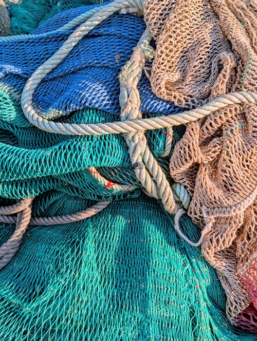 Free A vibrant close-up of tangled fishing nets and ropes in various colors and textures. Stock Photo
