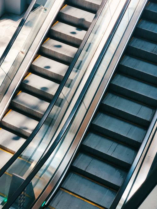 Free Stylish indoor view of modern escalators in a well-lit shopping mall. Stock Photo