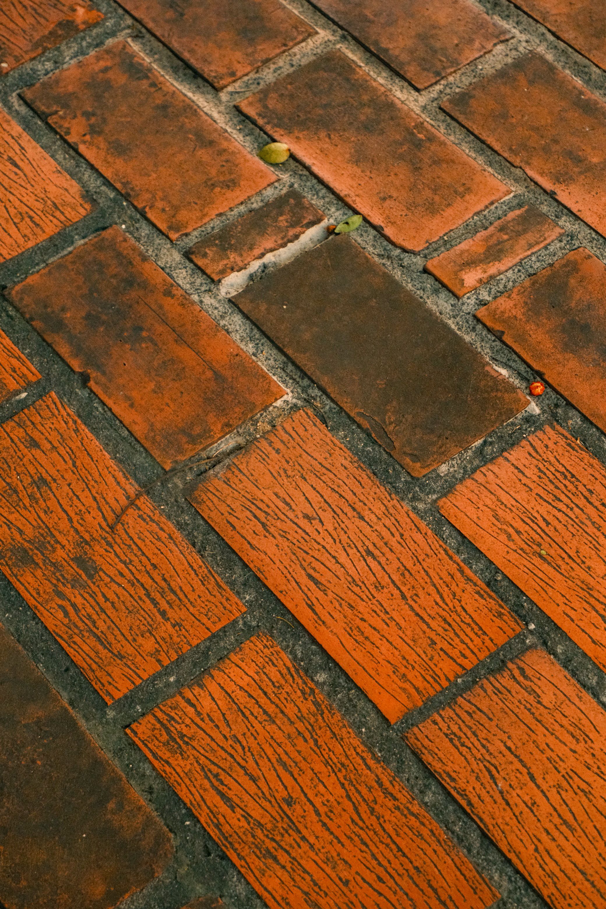 Close-up of red brick pavement showcasing weathered texture, perfect for architectural themes.