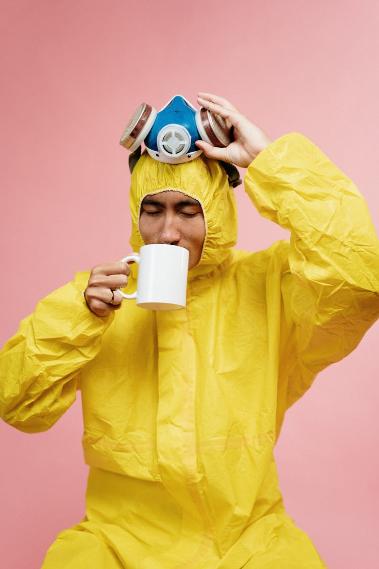 Man In Yellow Coveralls Holding Ceramic Mug