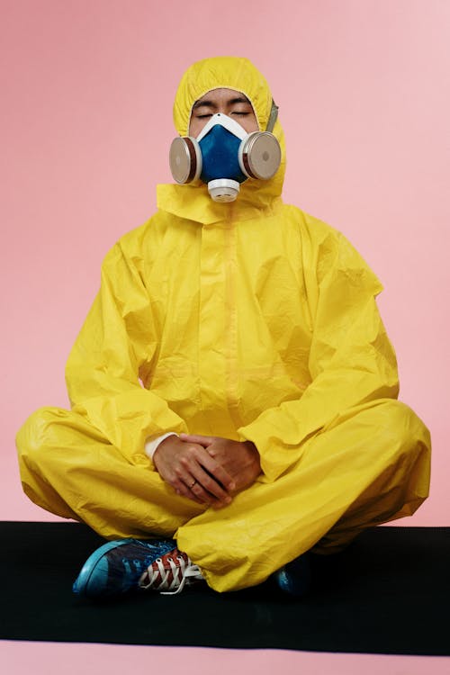 Free Person In Yellow Protective Suit Meditating Stock Photo