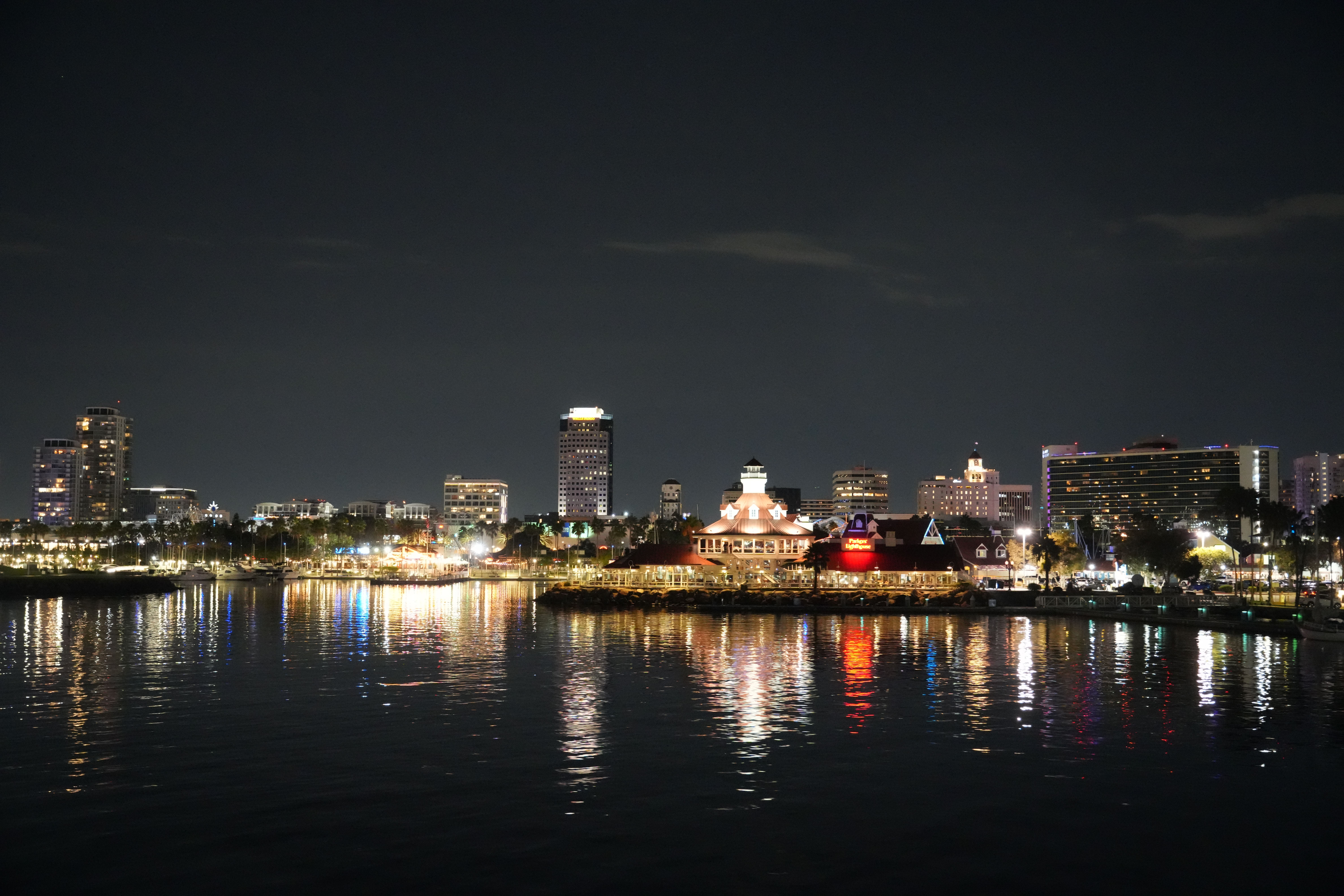 Beautiful cityscape at night with reflections on the water, showcasing vibrant city lights.