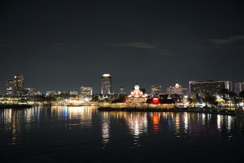 Beautiful cityscape at night with reflections on the water, showcasing vibrant city lights.