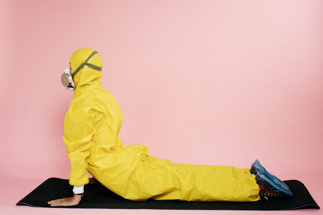 Free Man In Yellow Protective Suit Stretching Stock Photo