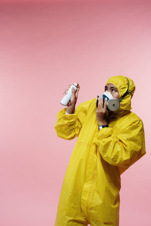 Free Man in Yellow Coveralls Holding Spray Bottle Stock Photo