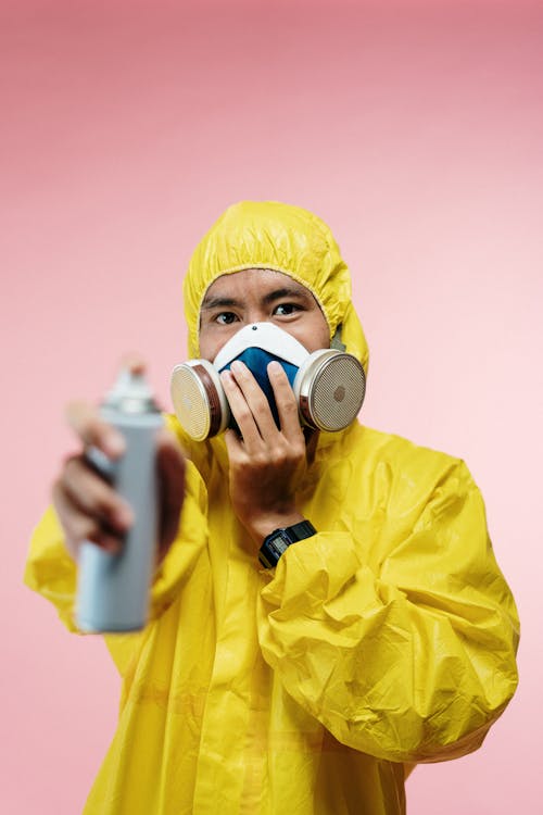 Man in Coveralls Holding Spray Bottle