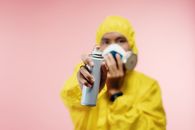 Man in Coveralls Holding Spray Bottle