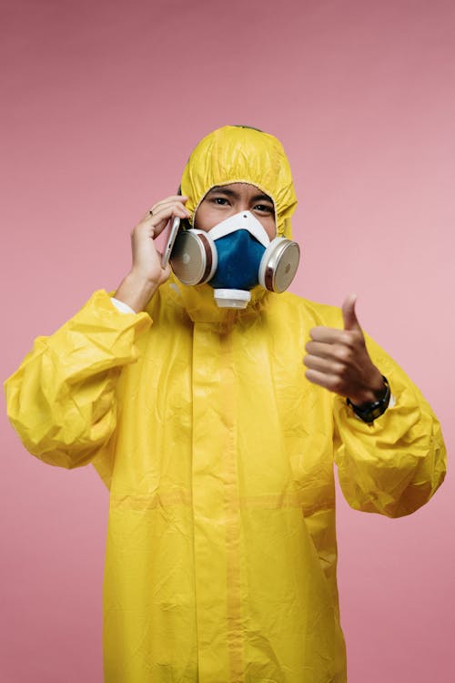 Free Person In Yellow Protective Suit Talking On The Phone Stock Photo