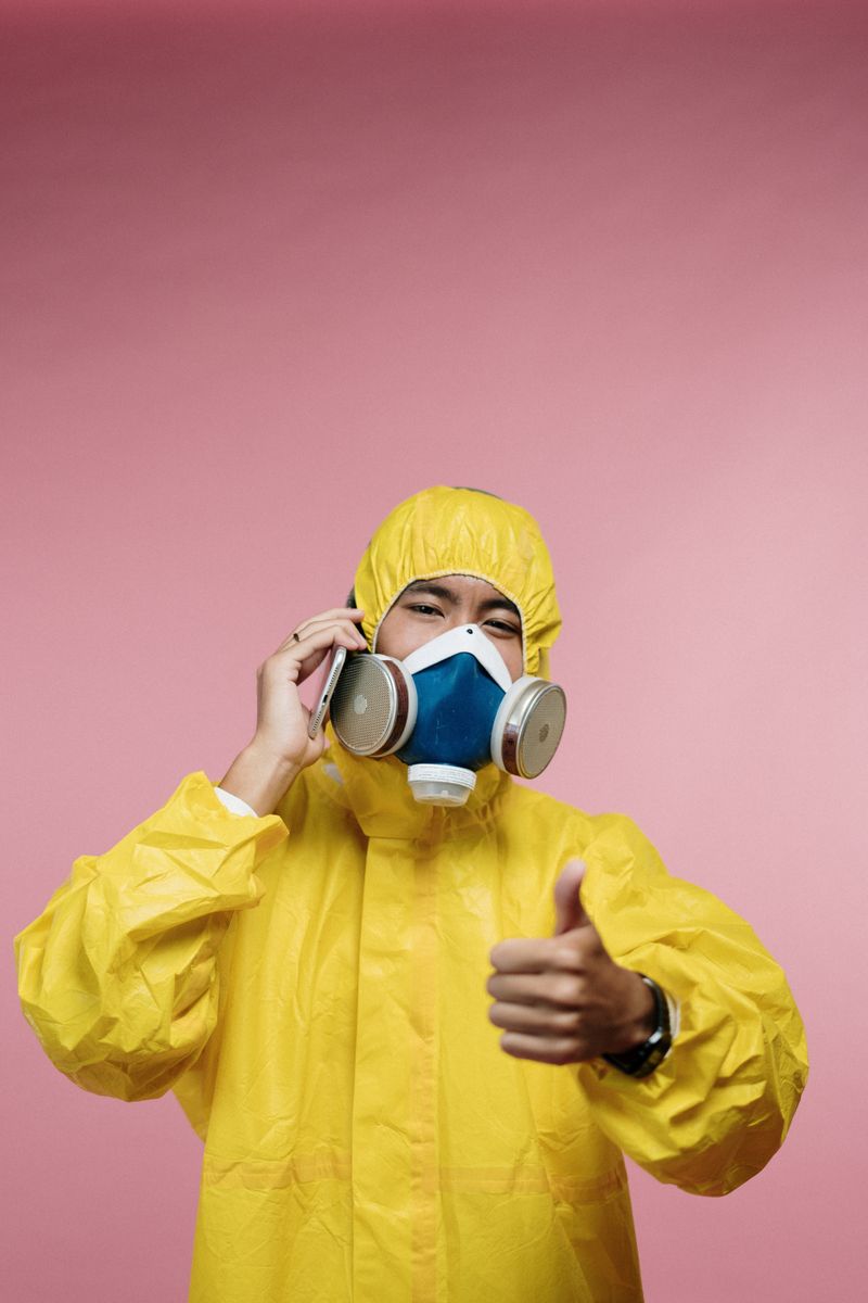 Technician in yellow coveralls applying treatment