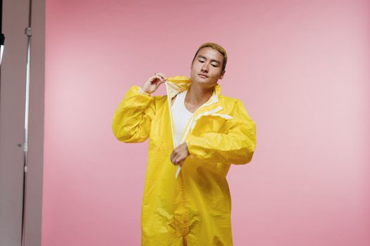 一名男子身穿黄色防护服，背景为粉色