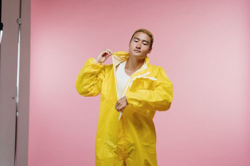 Free A man wearing a yellow protective suit against a pink background. Stock Photo