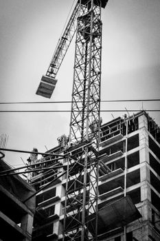 High-contrast black and white photo of a crane and building under construction in Guatemala.