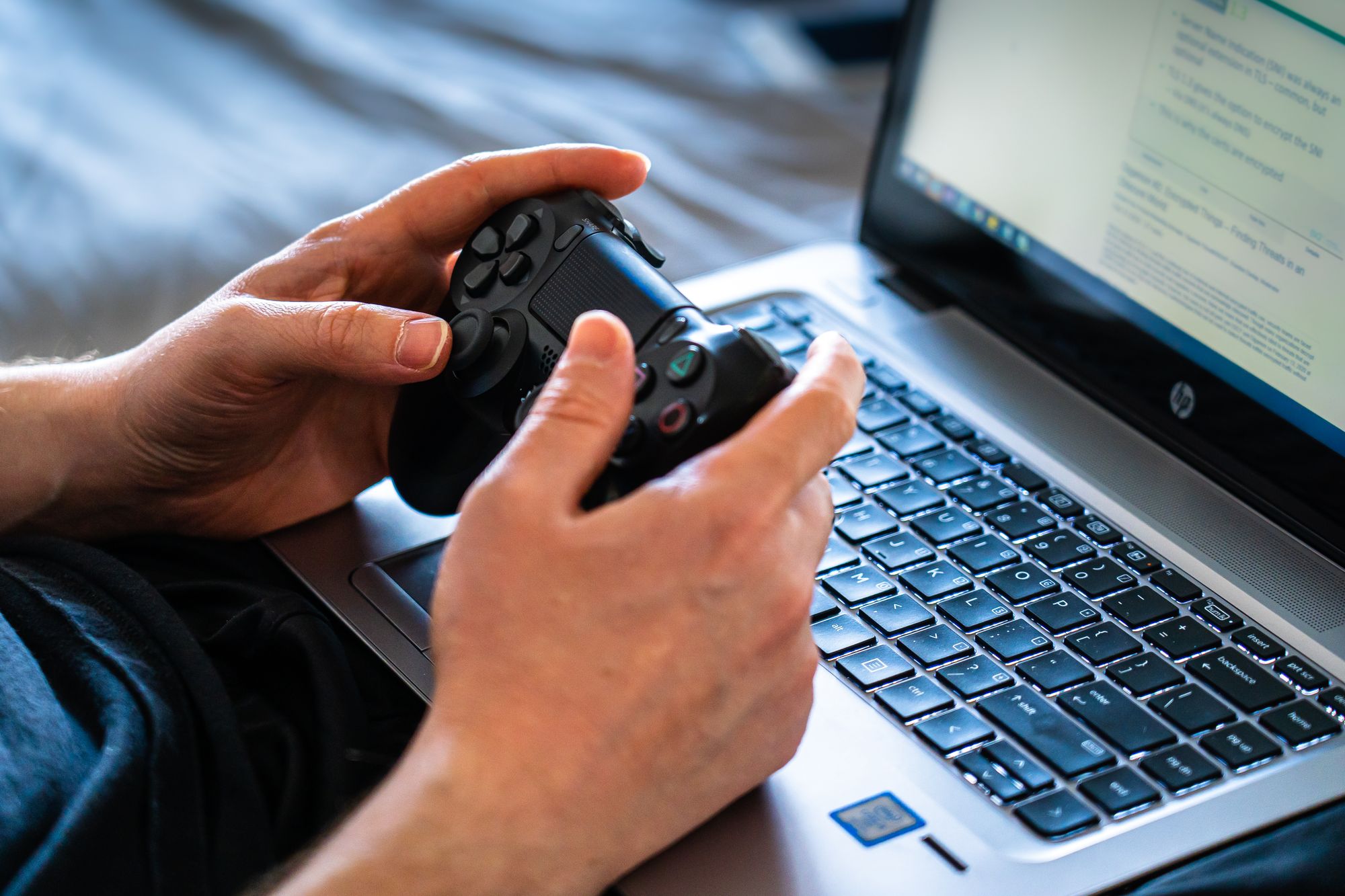 Persona sostiene una consola portátil tipo PC con ambas manos mientras juega