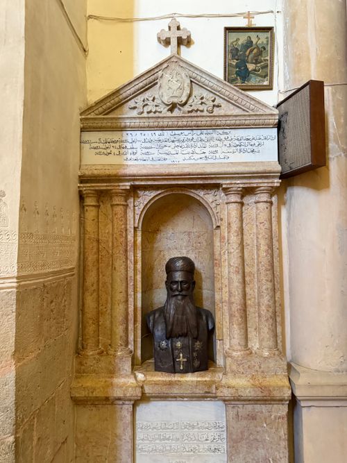 Free Intricate stone monument with a religious figure and inscription in a historic setting. Stock Photo