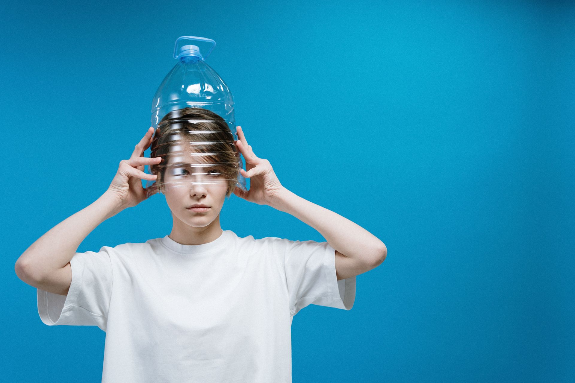 Woman using a plastic bottle as a makeshift mask, highlighting pandemic creativity.
