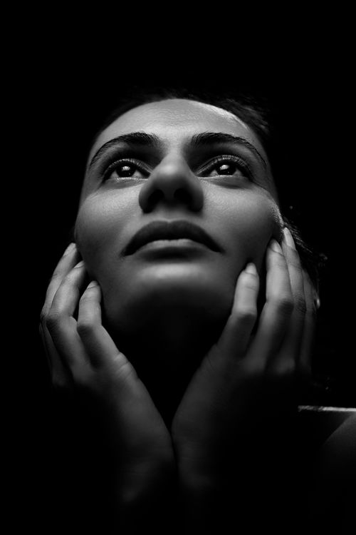 Free Striking black and white portrait of a woman gazing upwards, illuminated by dramatic lighting. Stock Photo