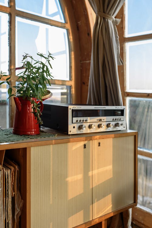 Free Vintage stereo radio set on music cabinet in wooden room with windows and plant in daytime nobody at home corner of room Stock Photo