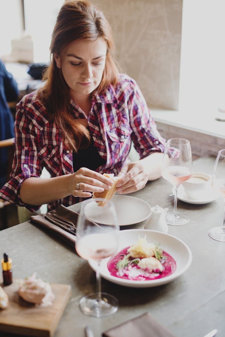 Young Woman Eating Sandwich In Restaurant