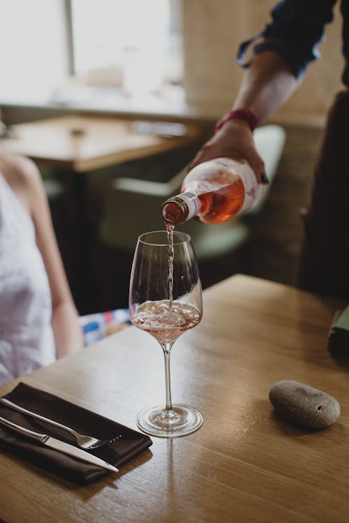 Free Person Pouring Wine on Clear Wine Glass Stock Photo