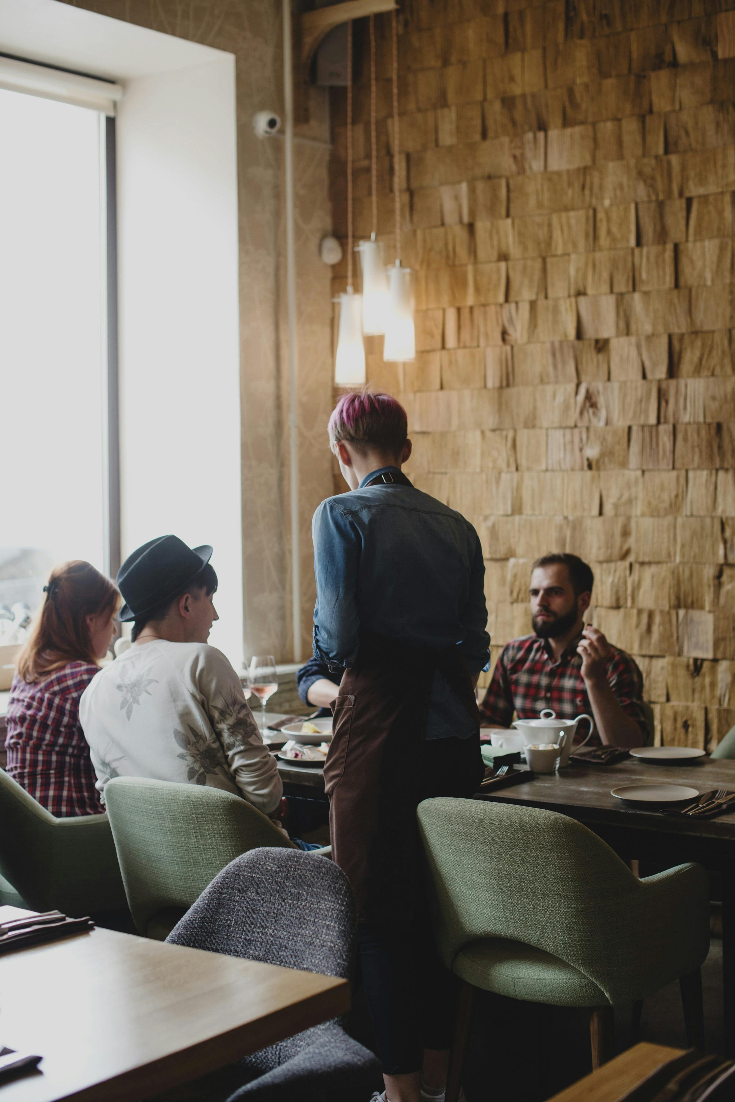 focused waiter talking with clients in restaurant