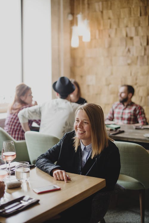 Happy woman sitting in crowdy cafe