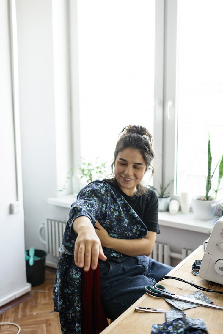 Woman Tailor Fitting Jacket In Workshop