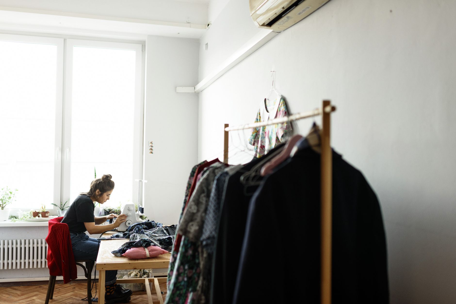 A home studio with garments and a sewing machine, the hands-on work cheap copies can make invisible.