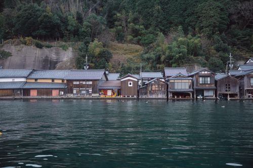 Free Scenic view of traditional wooden boathouses along the waterfront in Ine, Kyoto, Japan. Stock Photo