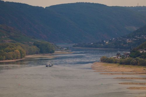 Free Picturesque landscape of the Rhine River with a boat and green hills in Bacharach, Germany. Stock Photo