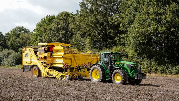 Agricultural machinery working in a field in Sauensiek, Niedersachsen, Germany, showcasing modern farming technology.