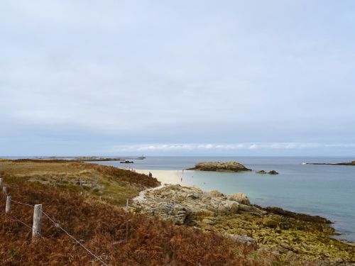 Free Serene coastal landscape with a rocky shoreline and calm sea, perfect for a relaxing getaway. Stock Photo