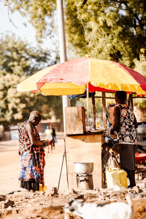 Free Women at a colorful street market stall in Northern Uganda focusing on local trade. Stock Photo