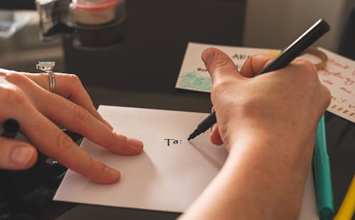 Persona Escribiendo En Papel Blanco