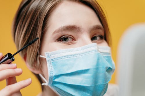 Free Woman Covering Face With Blue Face Mask Stock Photo