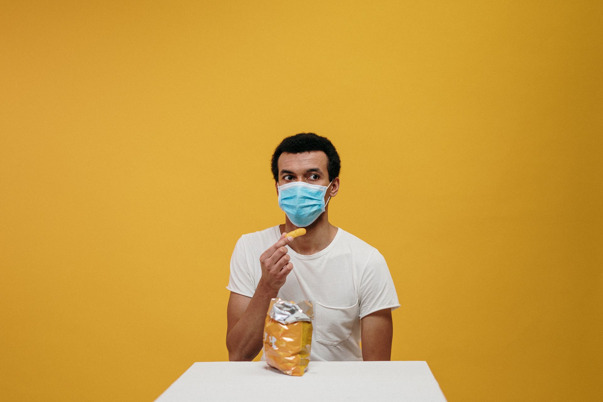 Man in White Crew Neck T-shirt Eating Chips
