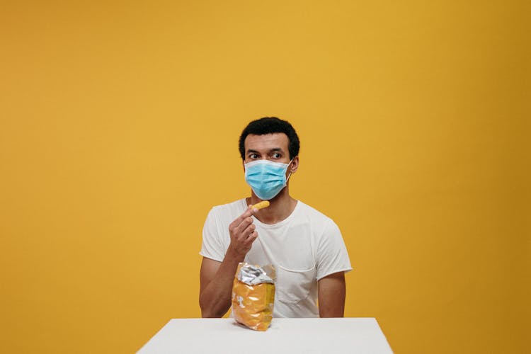 Man In White Crew Neck T-shirt Eating Chips