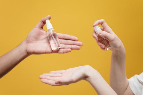 People Holding Clear Glass Bottle