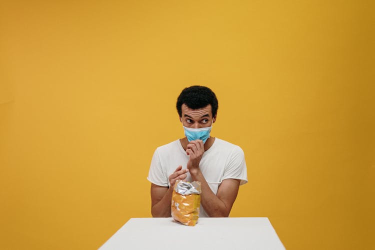 Man In White Crew Neck T-shirt Eating Chips