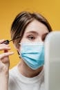 Woman in White Shirt Beautifying Herself Despite The Outbreak